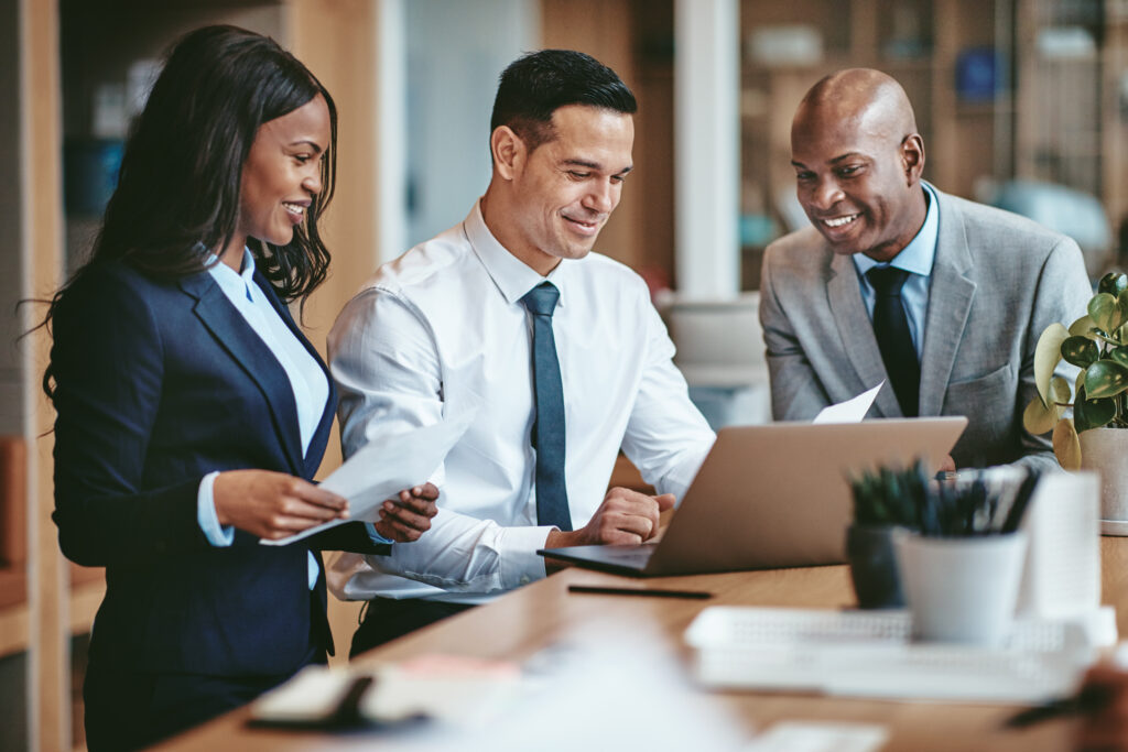 smiling,group,of,diverse,businesspeople,going,over,paperwork,together,and