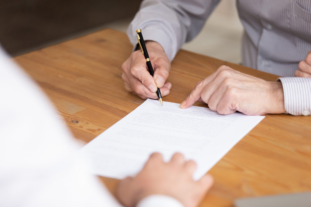 close,up,elderly,businessman,hand,holding,pen,put,signature,on