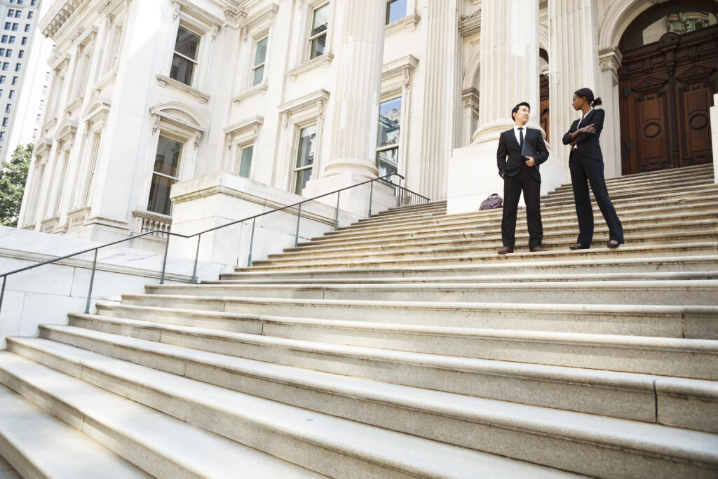 a,well,dressed,man,and,woman,converse,on,the,steps